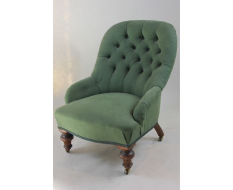 A Victorian nursing chair, button back on turned legs, with green upholstery
