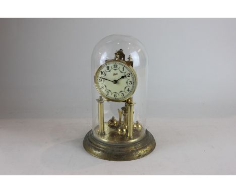 A brass anniversary clock, the circular enamel dial with Arabic numerals, signed Schatz, with floral swags under glass dome