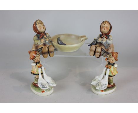 Four Goebel Hummel figures of girls, two with geese and two singing (one as an ashtray), tallest 10cm