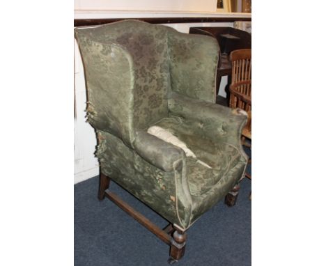 A Victorian wing back armchair with button sides, on turned mahogany legs with castors (a/f - needs re-upholstering) (NC)