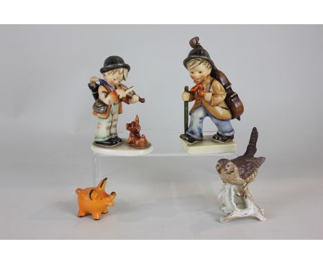 Two Goebel Hummel figures of boy musicians, a Goebel ornament of a wren and a small orange pig
