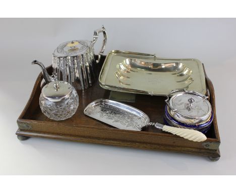 An oak tea tray with silver plated mounts, together with a silver plated teapot, cake basket, crumb scoop and two glass pots