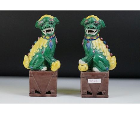 Pair of 20th Century Chinese ceramic Dogs of Foo figures in green and yellow glaze, raised on square-shaped bases, approx 25c