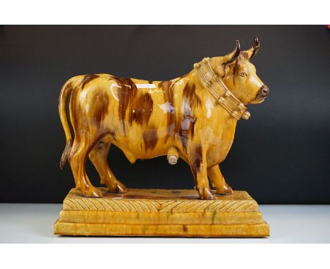 Slipware Wine Flask in the form of a Bull stood on a stepped plinth base, 37cm high x 39cm long 