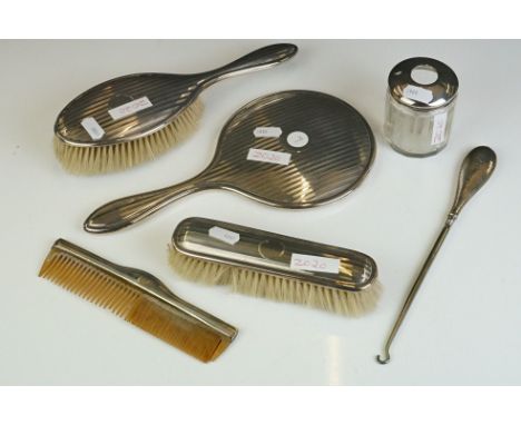 A fully hallmarked sterling silver art deco brush set to include two brushes, hand mirror and comb together with two button h