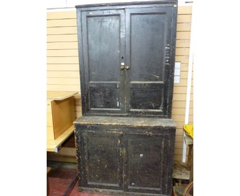AN EARLY 19th CENTURY PINE HOUSEKEEPER'S CUPBOARD having twin two panel upper doors and two base doors, opening to reveal int