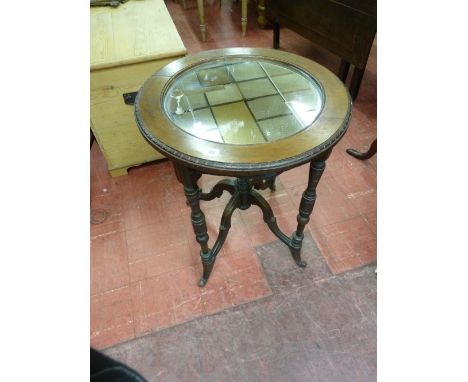 A MAHOGANY CIRCULAR SIDE TABLE with mirrored inset top, the 57 cms diameter top with carved edge detail on carved and turned 