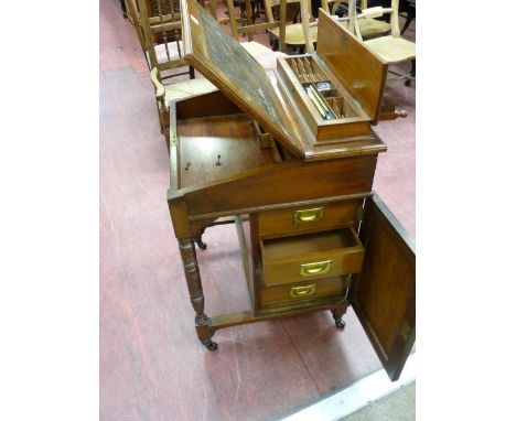 AN EDWARDIAN MAHOGANY DAVENPORT, the lift up top shelf with carved gallery detail opening to reveal an arrangement of wells a