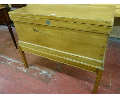 A VINTAGE PINE LIDDED BLANKET CHEST with brass carry handles on an associated stand, 81 cms high overall, 99 cms wide, 50 cms