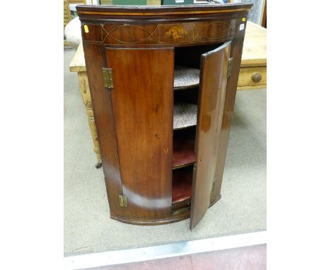 A GEORGIAN INLAID MAHOGANY WALL HANGING CORNER CUPBOARD with Sheraton shell inlay frieze panel above twin bow front doors wit