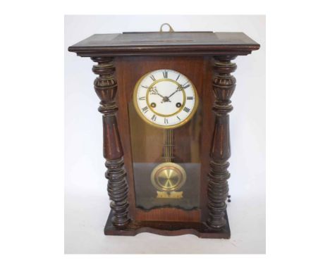 Early 20th century stained walnut and pine Vienna type wall clock, the overhanging cornice over half ring turned columns to a