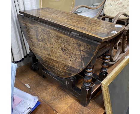 A Charles II low oak and fruitwood oval gateleg table (made-up), with a drawer, square and bobbin turned legs joined by stret