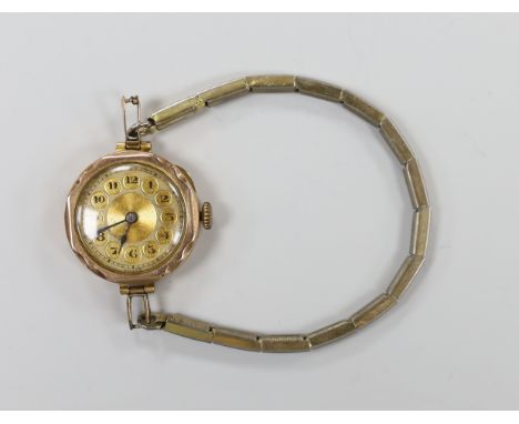 An early 20th century 9ct gold manual wind wrist watch, on a gilt metal flexible strap.