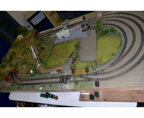 A 00 GAUGE MODEL RAILWAY LAYOUT, large double track oval with three sidings, laid on a chipboard base on a wooden frame, elec