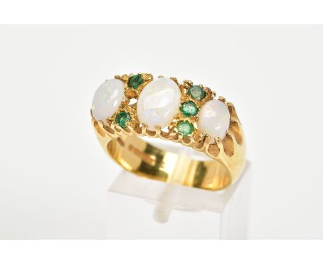 AN 18CT GOLD OPAL AND EMERALD RING, designed as three graduated oval opals, the central opal flanked by a vertical row of thr