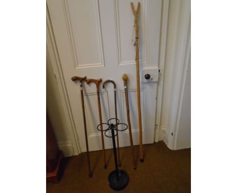 Metal stick stand with 4 walking sticks - one with carved fish handle and a thumb stick (5)