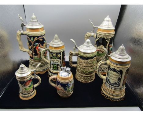 A collection of German and Jersey  musical steins and a table lighter