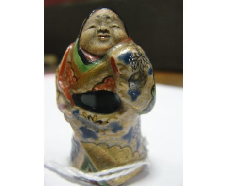 A Japanese Pottery Netsuke:
Meiji period
In the shape of a standing lady. Enamelled in colours and gold
H 4 cm 
 CONDITION RE