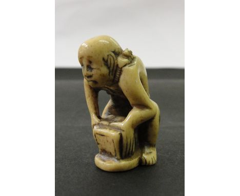 A Japanese Ivory Netsuke:
Meiji period
In the shape of a labourer lifting a weight
H 4 cm 
