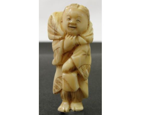 A Japanese Ivory Netsuke:
Meiji period
In the shape of a standing peasant carrying a bundle over his shoulders.
H 5 cm 
