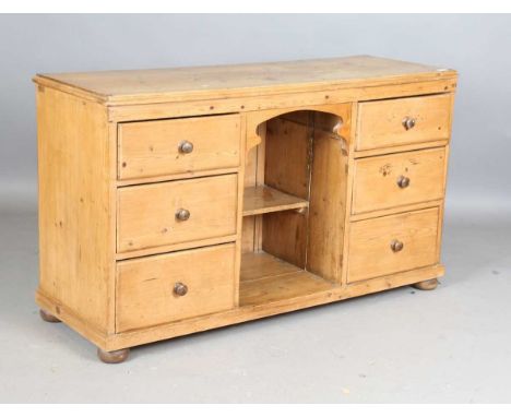 A late Victorian pine dresser base with central open shelf flanked by six drawers, height 77cm, width 135cm, depth 47cm.