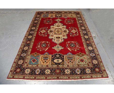 A Tabriz carpet, North-west Persia, late 20th century, the deep claret field with a bold ivory medallion, within a blue palme