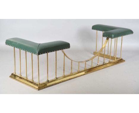 A 20th century gilt brass club fender with a green leather seat, height 50cm, width 176cm, depth 63cm.