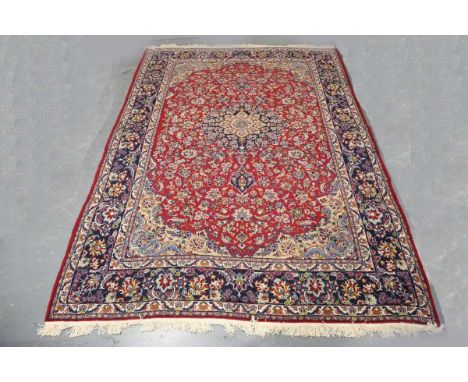 A Najafabad carpet, Central Persia, late 20th century, the red field with a flowerhead medallion, within a blue palmette and 