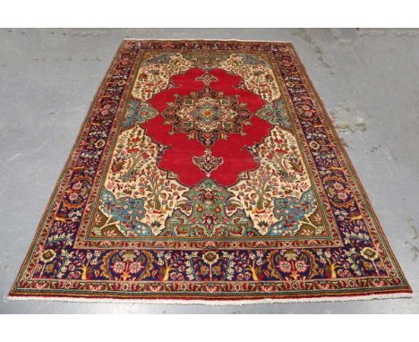 A Tabriz carpet, North-west Persia, late 20th century, the red field with a shaped medallion and large ivory spandrels, withi