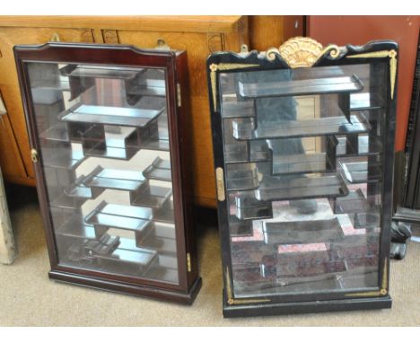 Two contemporary wall mounted glazed display cases set with a series of stepped shelves and mirrored backs suitable for the d