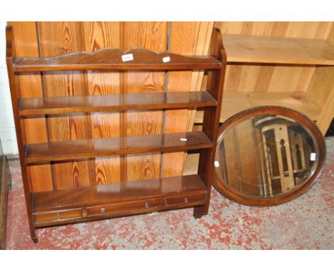A reproduction wall shelf unit with central drawer and two simulated drawers, width 76.5cm, and an oval bevelled mirror (2).