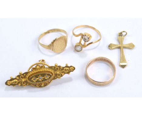 A small group of jewellery comprising a 15ct yellow gold brooch set with three white stones, a yellow metal cross pendant sta