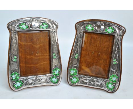SYNYER & BEDDOES; a pair of Edward VII hallmarked silver fronted Art Nouveau shaped rectangular frames embossed with stylised
