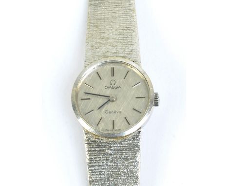 OMEGA; a lady's vintage 9ct white gold wristwatch with circular dial and textured integral strap, overall weight approx 27.1g