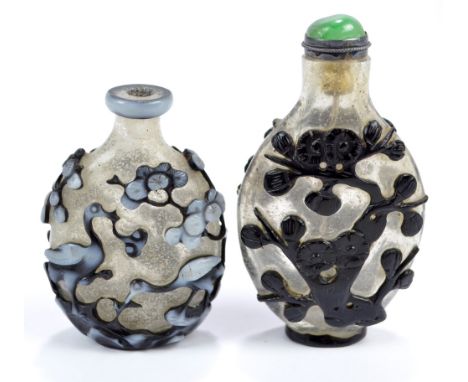 A Chinese double overlay white and black glass snuff bottle of flat ovoid form decorated with a deer to one side and two hero
