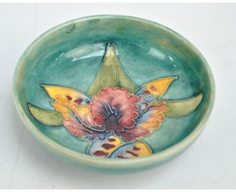 MOORCROFT; a tubeline decorated 'Orchid' pattern dish, impressed marks to base, diameter 11.5cm. CONDITION REPORT: Crazing, l