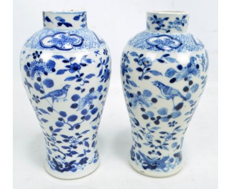 A pair of 19th century Chinese porcelain baluster vases with raised rims, painted in underglaze blue with birds amongst bloss