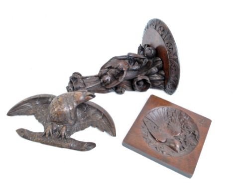 A carved wooden bracket modelled as a stork, length 31cm, a carved eagle on branch and a plaque with bird in relief to centre