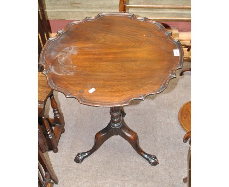 A reproduction mahogany tilt top occasional table, the one piece piecrust top above ring turned and lobed central column to t