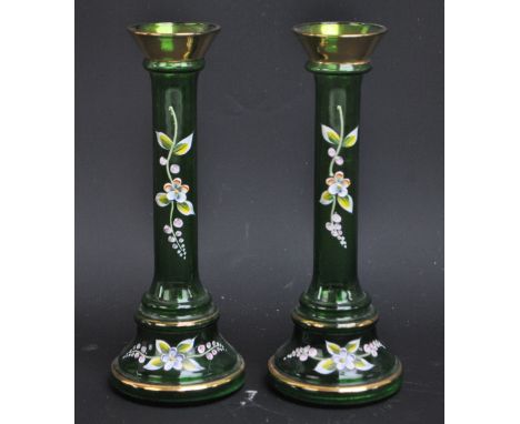 A pair of Victorian green glass candlesticks with painted and applied enamel floral sprays and gilt rims, height 20.5cm. COND