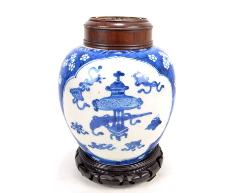 A 19th century Chinese porcelain ginger jar painted in underglaze blue with two opposing shaped panels depicting Buddhist aus