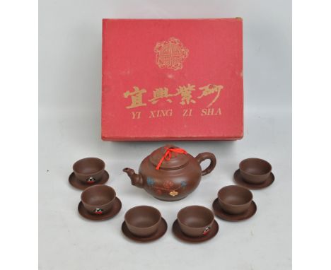A boxed Yixing type ceramic teapot and matching set of six teacups and saucers, Chinese character marks to bases.