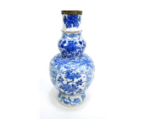 A Chinese Kangxi period porcelain double gourd vase with raised neck and domed foot, painted in underglaze blue with four flo