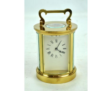 A mid to late 20th century cylindrical brass carriage clock, the white enamel dial set with Roman numerals and swing loop han