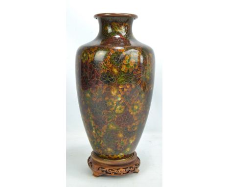 A large early 20th century Chinese cloisonné enamel vase of ovoid form with flared rim, overall decorated with various flower