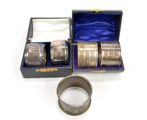JONES & CROMPTON; a cased pair of George V hallmarked silver circular engine turned napkin rings, London 1914, another cased 