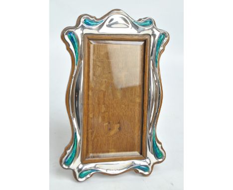 WILLIAM HAIR HASELER; an Edward VII hallmarked silver fronted Arts and Crafts shaped rectangular photo frame with turquoise e