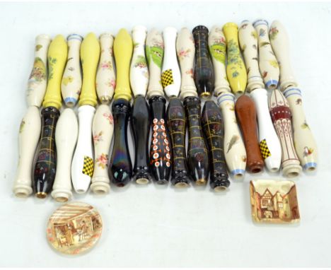A collection of approximately 30 ceramic beer pulls with floral, fishing and hunting decorated examples, the majority 24cm in