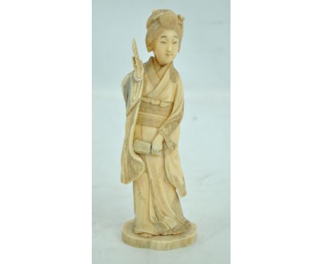 A Japanese Meiji period carved ivory okimono of a geisha with a fan, mark to base, height approx. 20.5cm. CONDITION REPORT: L
