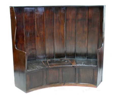 A late 18th century oak bow back box seat settle, with upright planks to the back, wing sides and central lifting seat, lengt
